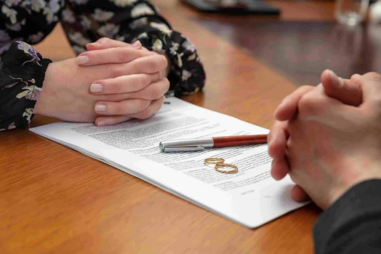 Divorce attorney consultation over legal papers with wedding rings and pen